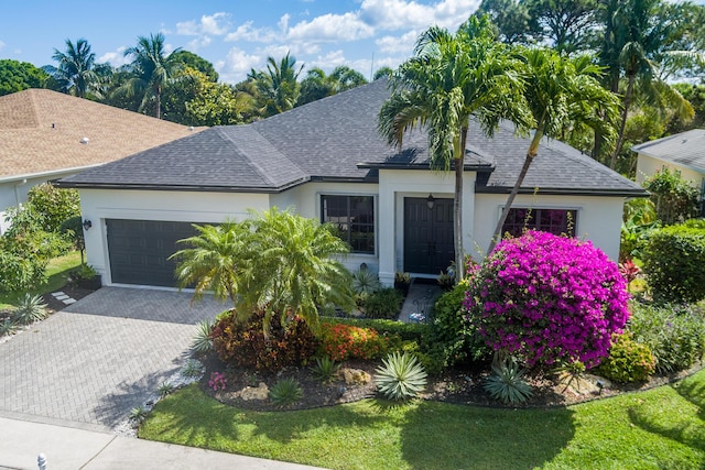 63 Lake Eden Dr, Boynton Beach, FL 33435 - view of front of home with roof with shingles, stucco siding, a garage, and decorative driveway