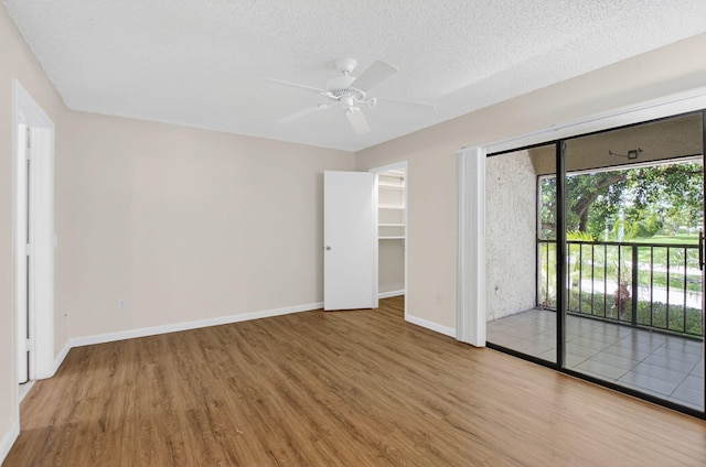9521 Boca Cove Cir Unit 508, Boca Raton, FL 33428 - unfurnished bedroom featuring wood finished floors, access to outside, a ceiling fan, and a textured ceiling