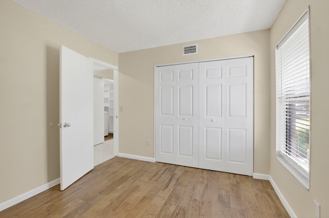 9521 Boca Cove Cir Unit 508, Boca Raton, FL 33428 - unfurnished bedroom featuring light wood finished floors, a textured ceiling, and a closet