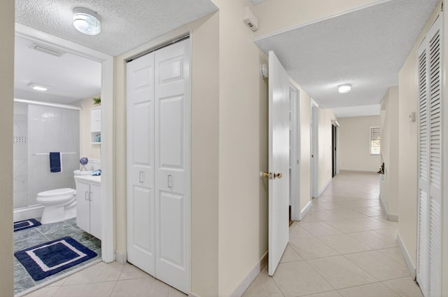9521 Boca Cove Cir Unit 508, Boca Raton, FL 33428 - corridor featuring a textured ceiling and light tile patterned floors