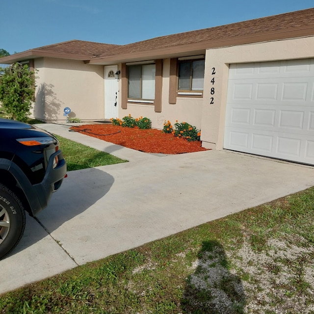 2482 SE Floresta Dr, Port Saint Lucie, FL 34984 - ranch-style home with stucco siding, a garage, and concrete driveway