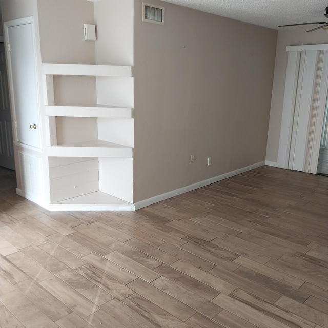 2482 SE Floresta Dr, Port Saint Lucie, FL 34984 - unfurnished room featuring wood finished floors, a ceiling fan, and a textured ceiling