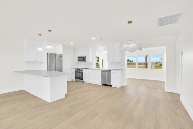 400 Riverside Dr, Palm Beach Gardens, FL 33410 - kitchen featuring appliances with stainless steel finishes, a peninsula, light wood-type flooring, white cabinets, and recessed lighting