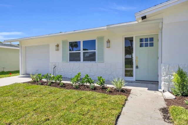400 Riverside Dr, Palm Beach Gardens, FL 33410 - view of exterior entry with a lawn, an attached garage, and driveway