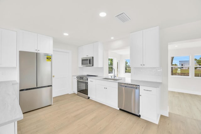 400 Riverside Dr, Palm Beach Gardens, FL 33410 - kitchen with stainless steel appliances, light wood finished floors, plenty of natural light, white cabinetry, and recessed lighting