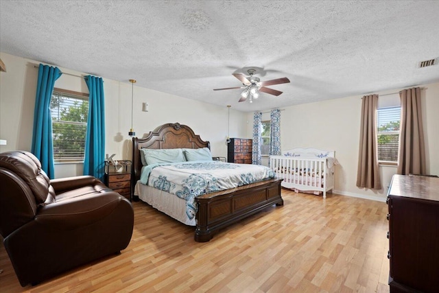 6015 Raintree Trl, Fort Pierce, FL 34982 - bedroom featuring light wood-style flooring, a textured ceiling, and ceiling fan