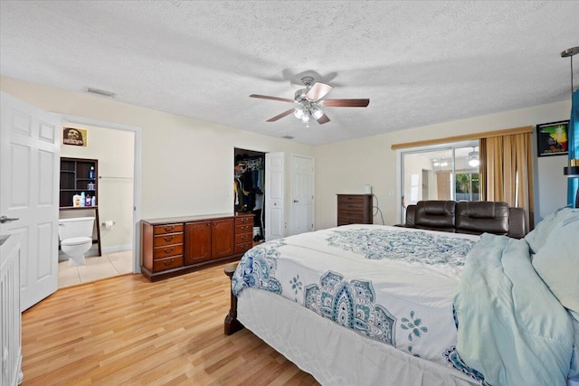 6015 Raintree Trl, Fort Pierce, FL 34982 - bedroom featuring light wood-style floors, a textured ceiling, connected bathroom, ceiling fan, and a closet