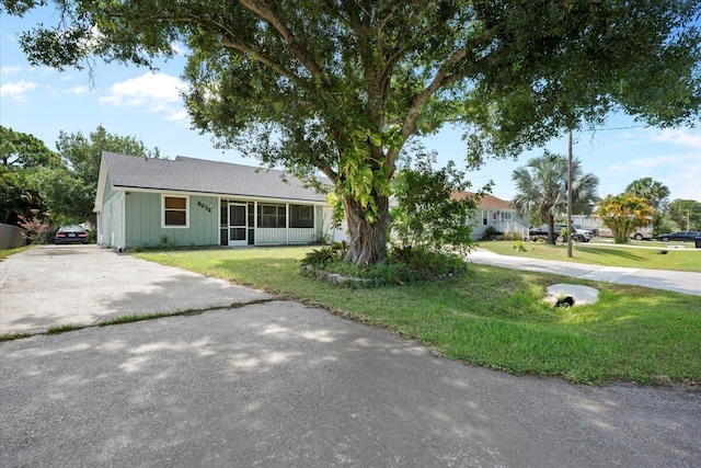 6015 Raintree Trl, Fort Pierce, FL 34982 - single story home with concrete driveway, a front yard, board and batten siding, and a sunroom