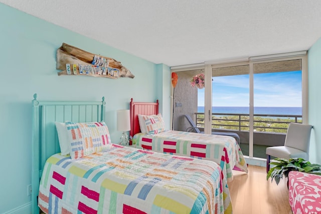4101 N Ocean Blvd Unit 908, Boca Raton, FL 33431 - bedroom featuring a water view, access to exterior, wood finished floors, and a wall of windows