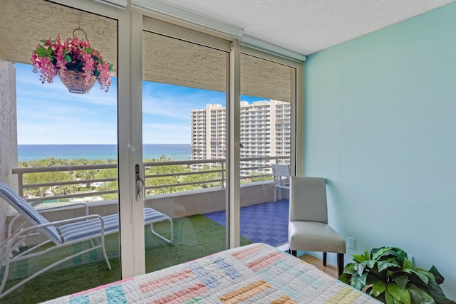 4101 N Ocean Blvd Unit 908, Boca Raton, FL 33431 - bedroom with multiple windows, a water view, expansive windows, and a textured ceiling