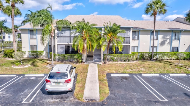 1102 Green Pine Blvd Unit A1, West Palm Beach, FL 33409 - view of building exterior featuring uncovered parking and stairs