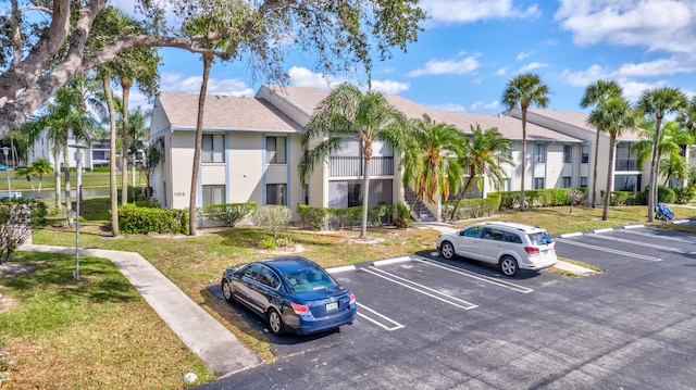 1102 Green Pine Blvd Unit A1, West Palm Beach, FL 33409 - view of property featuring uncovered parking, a residential view, and stairs