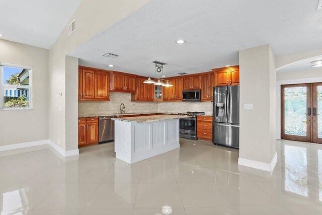 1555 SE 7th St, Deerfield Beach, FL 33441 - kitchen featuring appliances with stainless steel finishes, tasteful backsplash, arched walkways, light tile patterned flooring, and recessed lighting