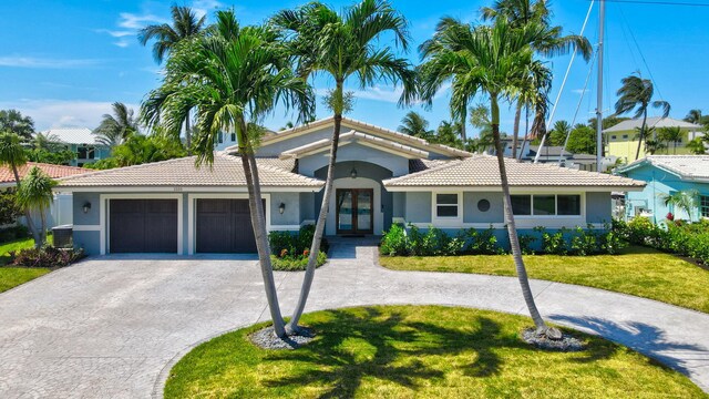 1555 SE 7th St, Deerfield Beach, FL 33441 - view of front of house featuring stucco siding, driveway, an attached garage, a tiled roof, and a front lawn