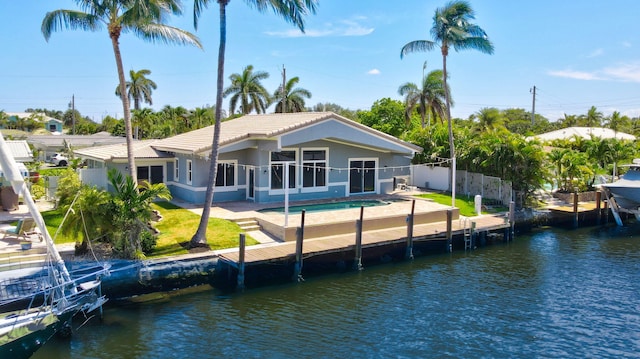 1555 SE 7th St, Deerfield Beach, FL 33441 - rear view of house with a tiled roof, a water view, an in-ground hot tub, and stucco siding