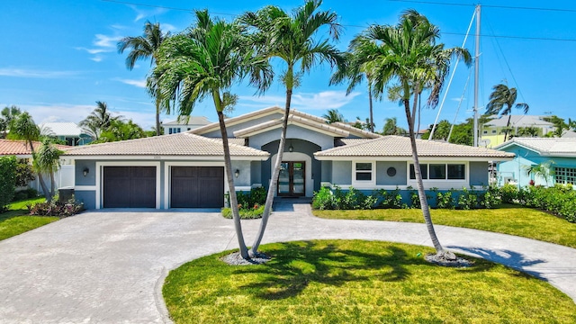1555 SE 7th St, Deerfield Beach, FL 33441 - view of front of property with french doors, curved driveway, a front lawn, stucco siding, and a garage
