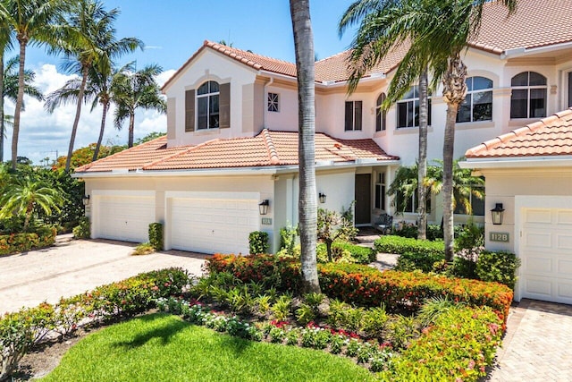 112 Palm Bay Dr Unit A, Palm Beach Gardens, FL 33418 - mediterranean / spanish home with concrete driveway, a tile roof, stucco siding, and an attached garage