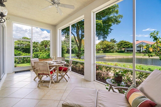 112 Palm Bay Dr Unit A, Palm Beach Gardens, FL 33418 - sunroom featuring outdoor dining area, a ceiling fan, tile patterned flooring, a textured ceiling, and a water view