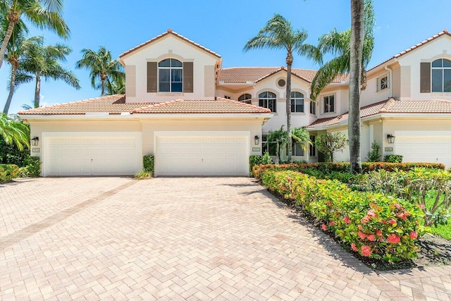112 Palm Bay Dr Unit A, Palm Beach Gardens, FL 33418 - mediterranean / spanish house featuring a tile roof, decorative driveway, a garage, and stucco siding