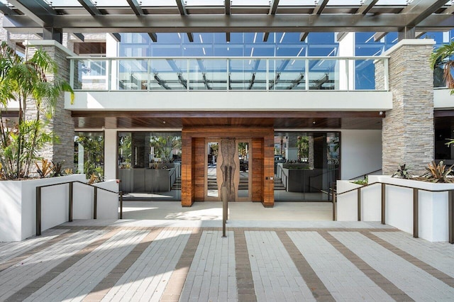 200 SE Mizner Blvd Unit 514, Boca Raton, FL 33432 - view of exterior entry featuring a balcony, a pergola, and french doors