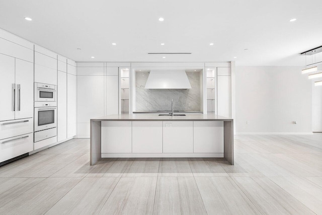 200 SE Mizner Blvd Unit 514, Boca Raton, FL 33432 - kitchen with modern cabinets, premium range hood, white double oven, white cabinets, and recessed lighting