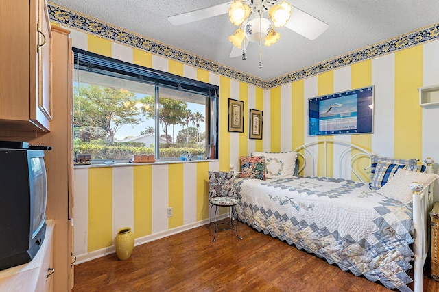 3186 Via Poinciana Unit 111, Lake Worth, FL 33467 - bedroom featuring wood finished floors, a textured ceiling, wallpapered walls, and ceiling fan