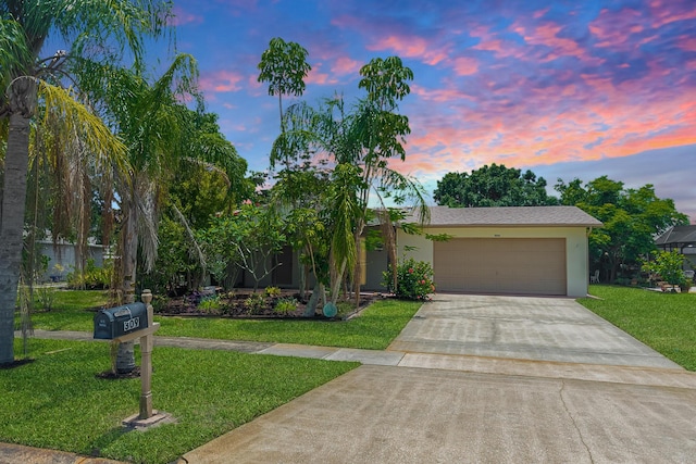 309 NE Jonquil St, Port Saint Lucie, FL 34983 - view of front of home with concrete driveway, a front yard, stucco siding, and a garage