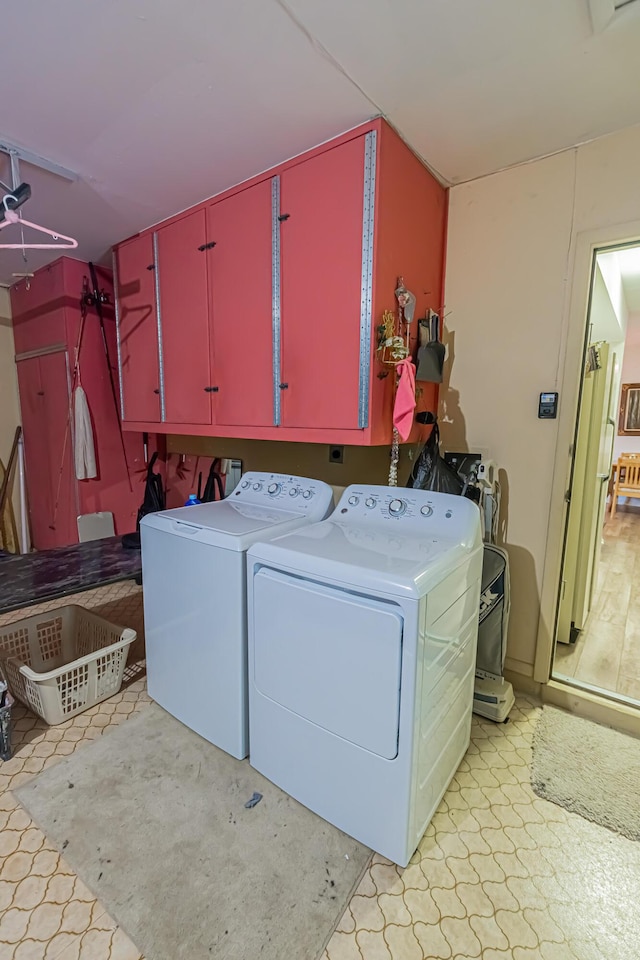 309 NE Jonquil St, Port Saint Lucie, FL 34983 - laundry room featuring cabinet space, washer and clothes dryer, and light floors