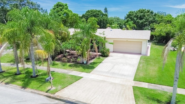 309 NE Jonquil St, Port Saint Lucie, FL 34983 - view of front of home with concrete driveway, an attached garage, and stucco siding