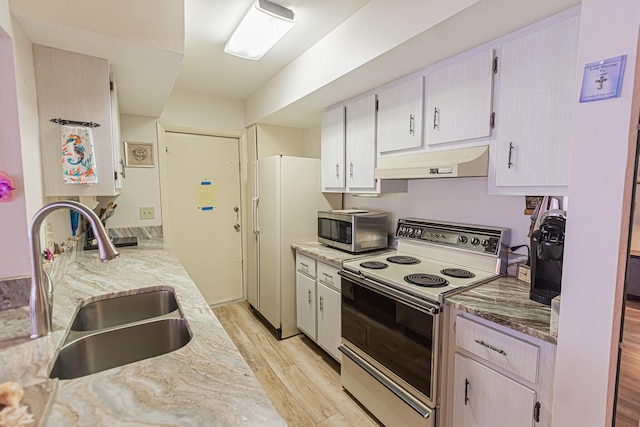 309 NE Jonquil St, Port Saint Lucie, FL 34983 - kitchen featuring white appliances, under cabinet range hood, light wood-style flooring, and light stone countertops
