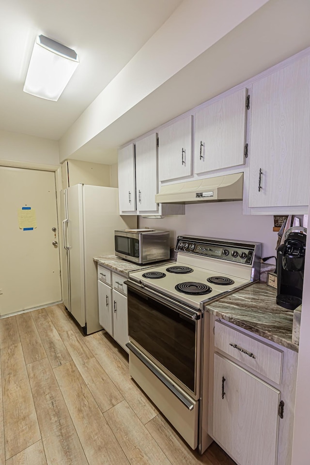 309 NE Jonquil St, Port Saint Lucie, FL 34983 - kitchen with white appliances, under cabinet range hood, and light wood-type flooring