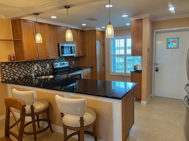 1868 SW Palm City Rd Unit 304, Stuart, FL 34994 - kitchen with appliances with stainless steel finishes, a peninsula, brown cabinetry, dark countertops, and ornamental molding