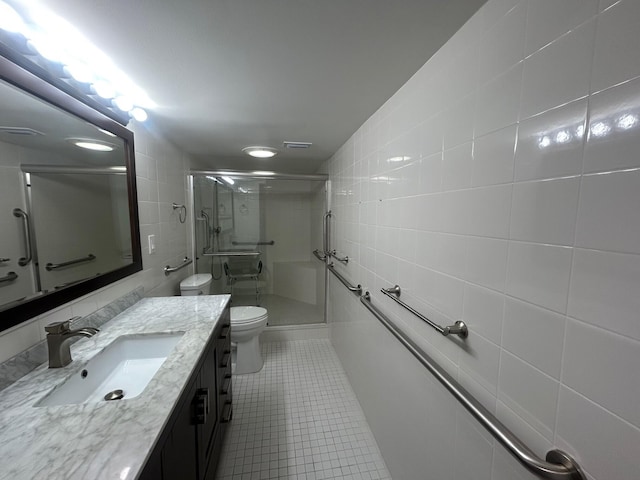 1868 SW Palm City Rd Unit 304, Stuart, FL 34994 - bathroom featuring tile walls, tile patterned flooring, a shower stall, and vanity