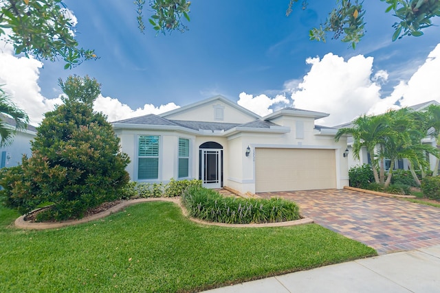 12736 SW Cattleya Ln, Port Saint Lucie, FL 34987 - view of front of property with decorative driveway, stucco siding, a front yard, and a garage
