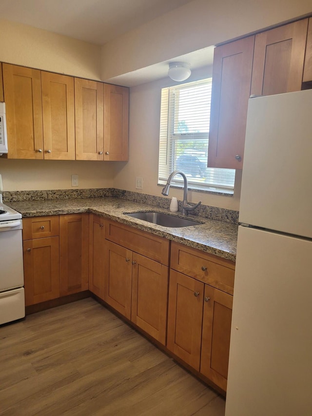 7891 Loomis St Unit 7891/7893, Lake Worth, FL 33462 - kitchen with white appliances, light wood finished floors, and brown cabinets