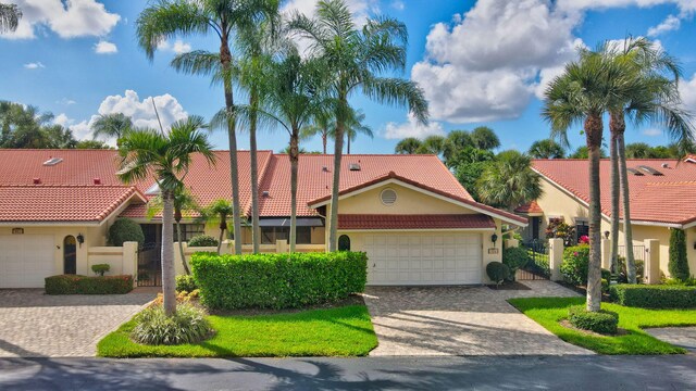 574 Emerald Way E, Deerfield Beach, FL 33442 - view of front facade with a tiled roof, stucco siding, a gate, and decorative driveway