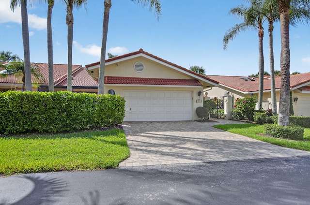 574 Emerald Way E, Deerfield Beach, FL 33442 - view of front of property with a tiled roof, a garage, stucco siding, and decorative driveway