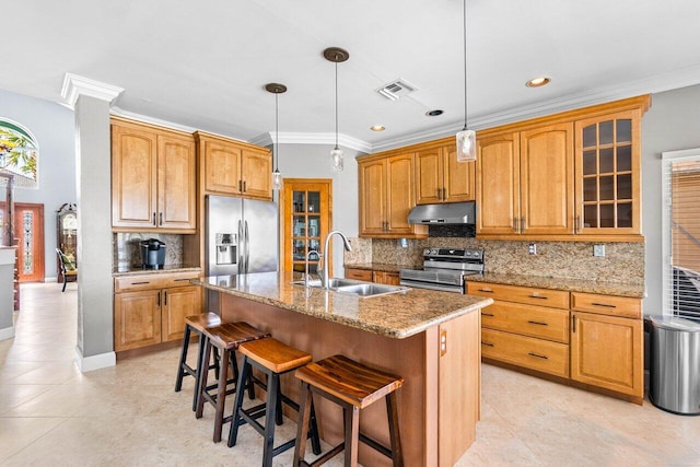 7141 Charleston Point Dr, Lake Worth, FL 33467 - kitchen featuring appliances with stainless steel finishes, under cabinet range hood, a breakfast bar, decorative backsplash, and a kitchen island with sink