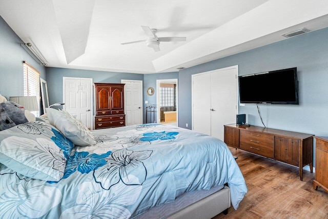 7141 Charleston Point Dr, Lake Worth, FL 33467 - bedroom with wood finished floors, a ceiling fan, ensuite bathroom, and a tray ceiling