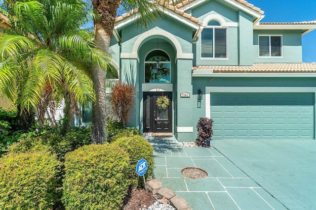 7141 Charleston Point Dr, Lake Worth, FL 33467 - view of front of home featuring a tile roof, stucco siding, an attached garage, and driveway