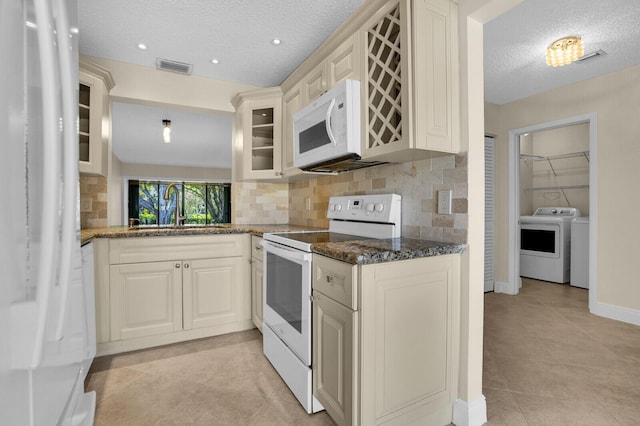 3741 English D Ln Unit D, Lake Worth, FL 33467 - kitchen with white appliances, washing machine and dryer, a textured ceiling, glass insert cabinets, and backsplash