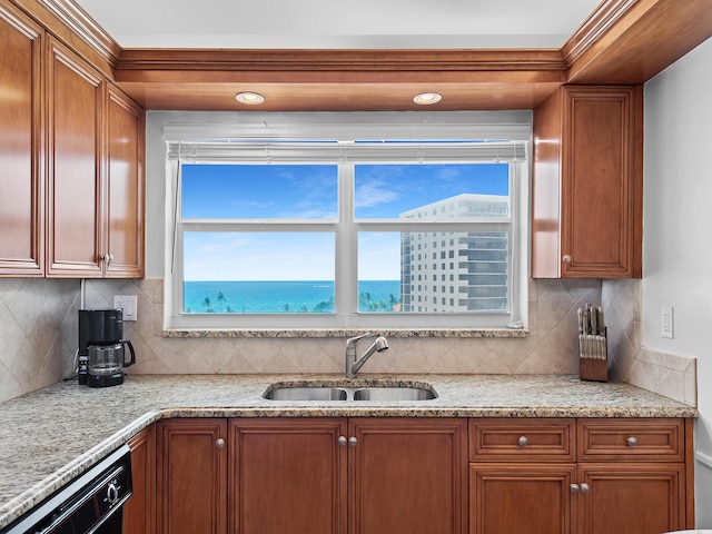 3310 S Ocean Blvd Unit 928D, Highland Beach, FL 33487 - kitchen featuring dishwashing machine, brown cabinetry, backsplash, and light stone countertops