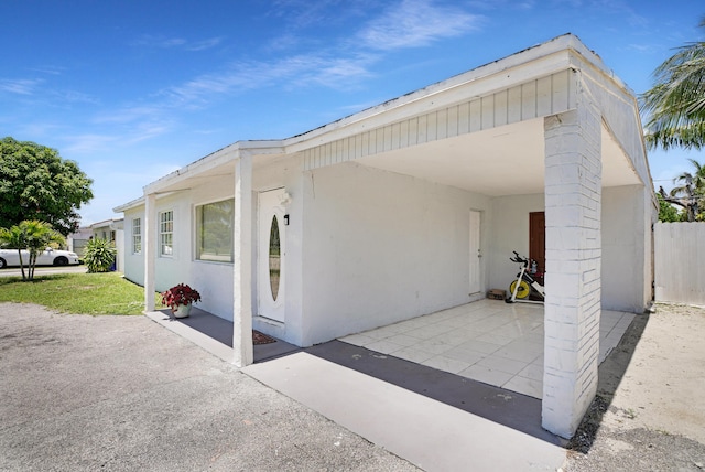1395 SW 46 Th Ave, Fort Lauderdale, FL 33317 - view of side of home featuring a patio and stucco siding