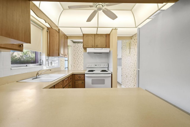 1900 S Kanner Hwy Unit 3-108, Stuart, FL 34994 - kitchen featuring white electric range, under cabinet range hood, a ceiling fan, light countertops, and brown cabinetry