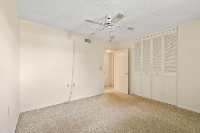 1900 S Kanner Hwy Unit 3-108, Stuart, FL 34994 - unfurnished bedroom with carpet floors, a textured ceiling, ceiling fan, and a closet