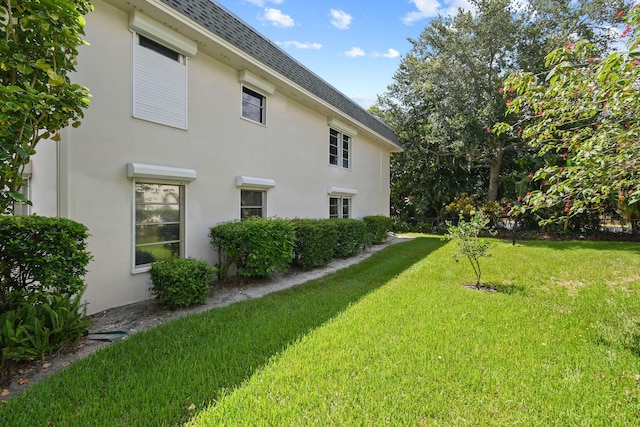 1900 S Kanner Hwy Unit 3-108, Stuart, FL 34994 - view of home's exterior with roof with shingles, a yard, and stucco siding