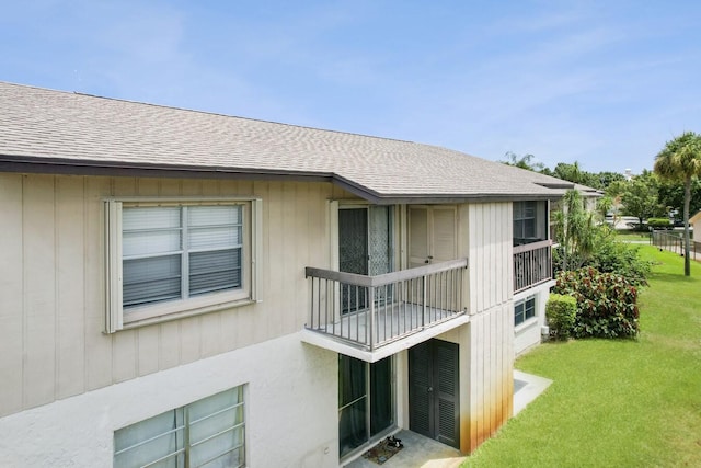 2755 W Atlantic Ave Unit C 212, Delray Beach, FL 33445 - rear view of property featuring a shingled roof, a lawn, and a balcony