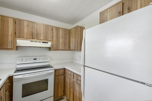 2755 W Atlantic Ave Unit C 212, Delray Beach, FL 33445 - kitchen with white appliances, under cabinet range hood, light countertops, and brown cabinets