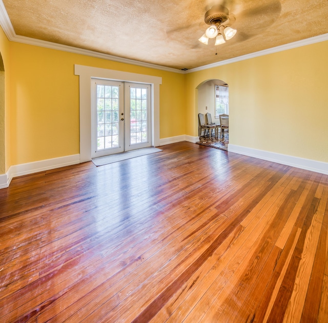 624 10th Ave N, Lake Worth Beach, FL 33460 - empty room with arched walkways, hardwood / wood-style floors, a ceiling fan, french doors, and ornamental molding