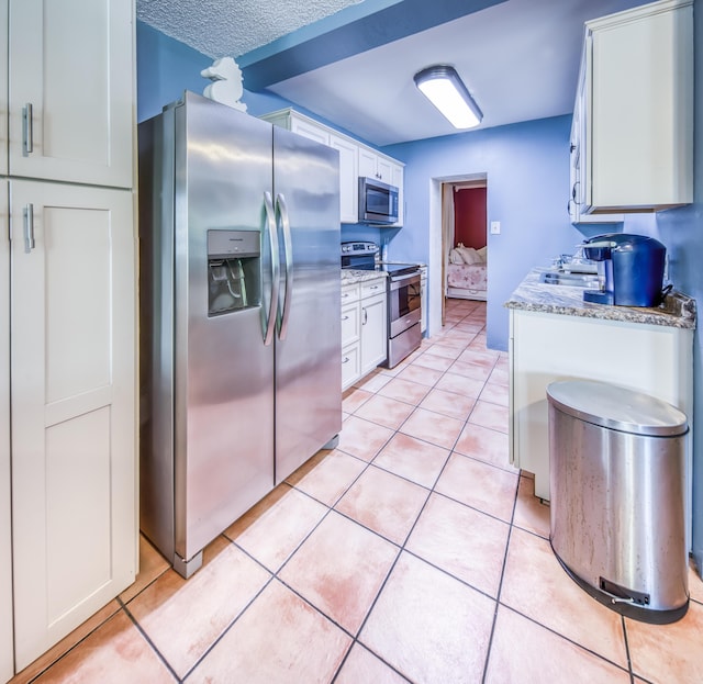 624 10th Ave N, Lake Worth Beach, FL 33460 - kitchen with stainless steel appliances, white cabinets, and light tile patterned flooring